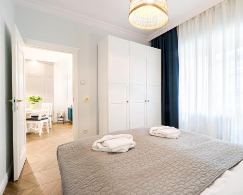 a bedroom with a bed with two towels on it at Azure Apartment by Baltic Home in Świnoujście