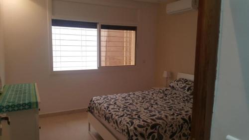 a bedroom with a bed and a window at La perle de saidia in Saidia 
