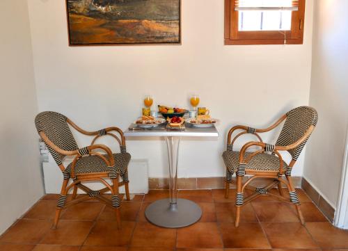duas cadeiras e uma mesa com um prato de comida em Loft Apartment , La Terrasse Centre Ville d'Arles, em Arles