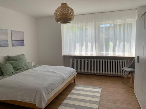 um quarto com uma cama grande e uma janela em Ferienwohnung Alpenstraße em Friedrichshafen