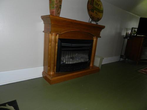 a wooden fireplace in a room with a green floor at Helming Guest House in Hermann