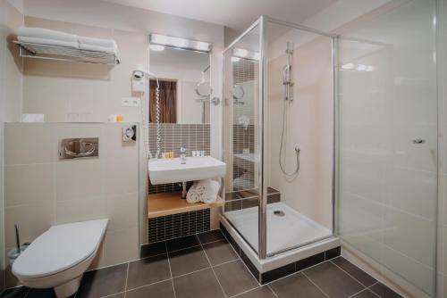 a bathroom with a shower, toilet and sink at Iris Hotel Eden - Czech Leading Hotels in Prague