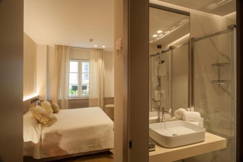 a bathroom with a bed and a sink and a shower at Locanda Cavour in Bergamo