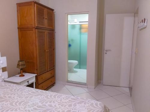 um quarto com uma cama e uma casa de banho com um WC em Guarujá Enseada - A Beira da Praia ao lado do Shopping - Wifi - Vaga Garagem no Guarujá