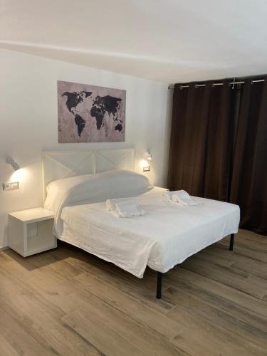 a bedroom with a white bed with a map on the wall at San Giuseppe Suite in Riva del Garda