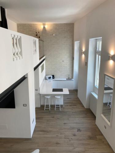 a white kitchen with a table and a dining room at San Giuseppe Suite in Riva del Garda