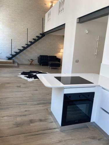 a living room with a kitchen and a staircase at San Giuseppe Suite in Riva del Garda