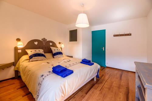 a bedroom with a large bed with blue bags on it at St Lary/Vignec: Les 3 Flocons in Vignec