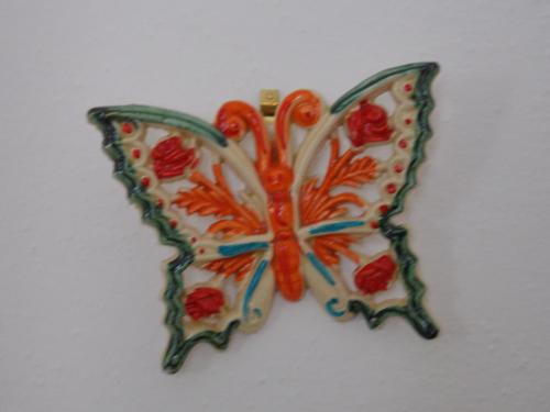 a colorful glass butterfly ornament on a white background at Villa Loreta in Ischia