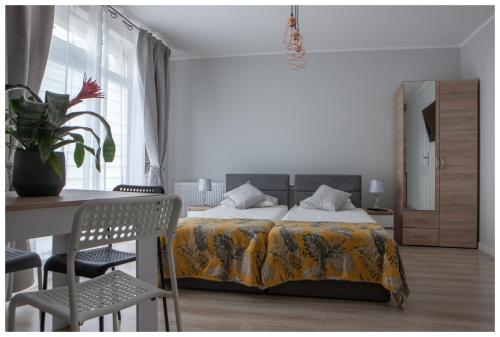 sypialnia z łóżkiem, stołem i krzesłami w obiekcie Pokoje na wynajem w Gdańsku