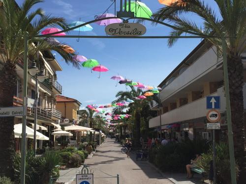a street with umbrellas hanging over a sidewalk at Hotel Verdesolemare in Marina di Pietrasanta