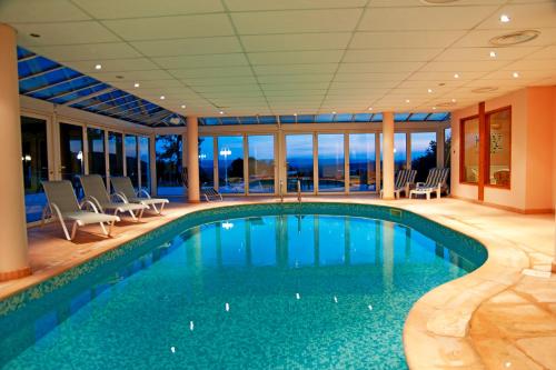 - une piscine dans une maison avec fenêtres dans l'établissement Hôtel les Bergeronnettes, à Champagneux