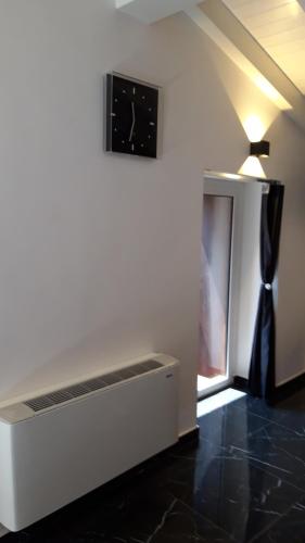a living room with a clock on the wall at Anteros Luxury Suite in Montalbano Elicona