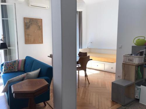 ein Wohnzimmer mit einem blauen Sofa und einem Tisch in der Unterkunft Nissa la Bella in Nizza