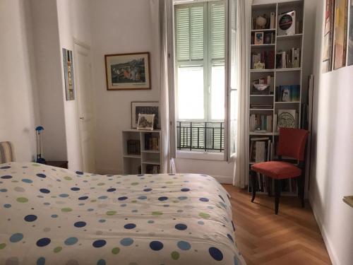 ein Schlafzimmer mit einem Bett, einem Fenster und einem Stuhl in der Unterkunft Nissa la Bella in Nizza