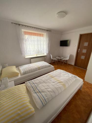 a bedroom with two beds and a television at Agroturystyka u Jana in Parowa