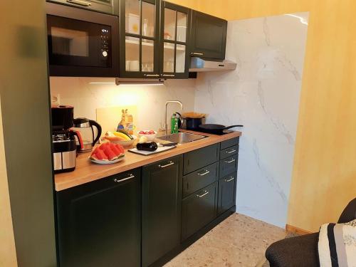 a small kitchen with green cabinets and a sink at Ferienwohnung Petronela in Waren