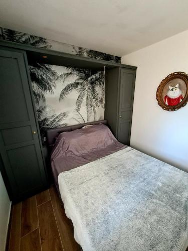 - une chambre avec un lit doté d'une tête de lit verte dans l'établissement Appartement bord de mer, à La Ciotat