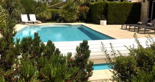 una gran piscina en un patio con arbustos en Domaine de la Ronce en Cézac