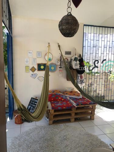 a bedroom with a hammock and a bed and a window at Hostel das Canárias in Natal