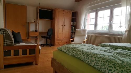 a bedroom with two beds and a chair and a window at Hofgestüt Bleesern FEWO2 in Bleesern
