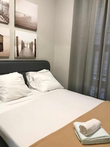 un lit avec des draps blancs et des serviettes dessus dans l'établissement Dreamplace, à Nice