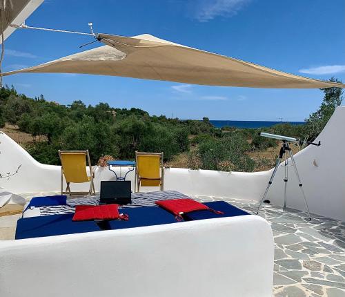 a room with a table and chairs and an umbrella at Summer House in Porto Heli