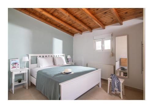 a white bedroom with a bed and a table at Baulus Yard Luxury I in Heraklio Town