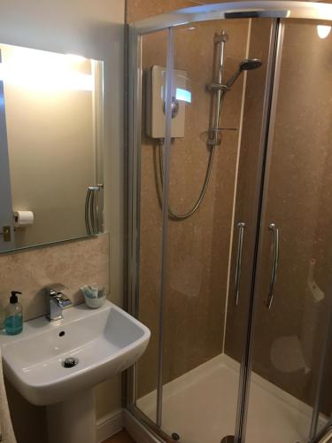 uma casa de banho com um chuveiro e um lavatório. em The Greyhound Inn em Bedale
