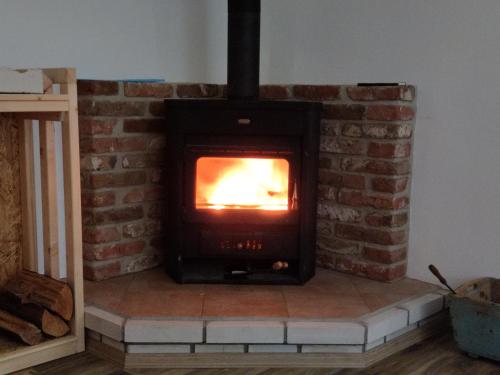 a brick fireplace with a fire in it at Chalupa v Okrouhlé Radouni in Okrouhlá Radouň