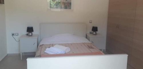 a bedroom with a bed with two tables and two towels at Dora's apartment in Peroulades