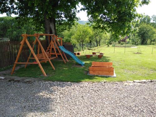 a playground with a slide and a swing set at Noclegi u Marcela in Ustrzyki Dolne
