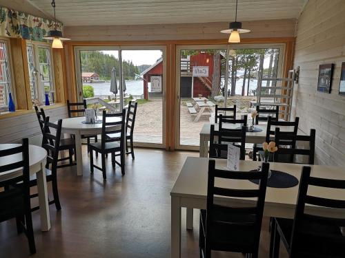 a restaurant with tables and chairs and a patio at Trysunda Vandrarhem & Skärgårdscafé 