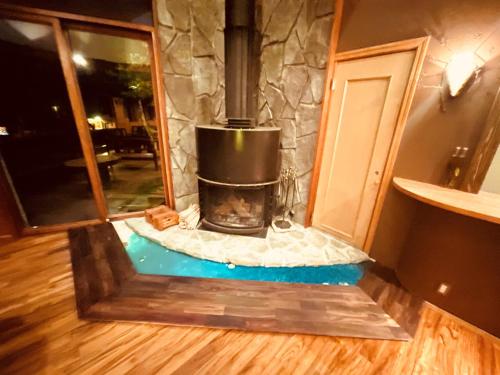 a fireplace in the middle of a room at Nikko Akarinoyado Villa Revage in Nikko