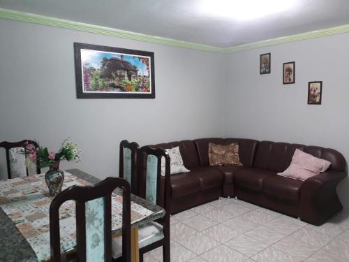 ein Wohnzimmer mit einem braunen Sofa und einem Tisch in der Unterkunft Apartamento 1 Boa Vista 1 Caruaru in Caruaru