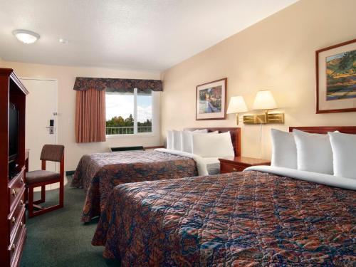 a hotel room with two beds and two lamps at Travelodge by Wyndham Drumheller AB in Drumheller