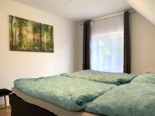 two beds sitting next to a window in a bedroom at Ferienwohnung Mühlendamm in Bergen