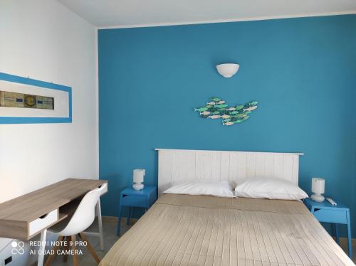 um quarto com uma cama com uma parede azul em la lampara em Favignana