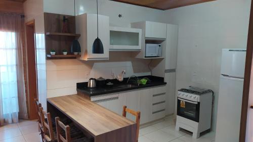 a kitchen with white cabinets and a counter top at Apartamento Serrano 2 in São Joaquim