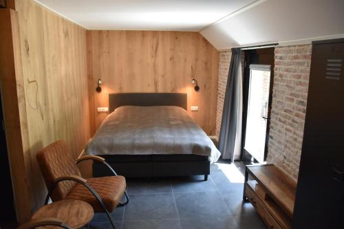 a bedroom with a bed in a room with wooden walls at De Kasteelboerderij in Ruurlo