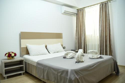 a bedroom with two stuffed animals on a bed at Ideal MoonLight Residence in Mamaia