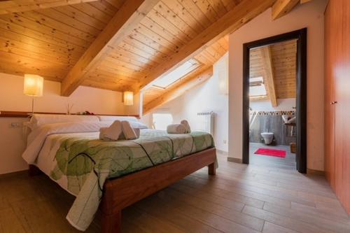 a bedroom with a large bed with a wooden ceiling at Il Finto Pepe di Alessia in Formia