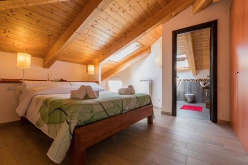 a bedroom with a large bed with a wooden ceiling at Il Finto Pepe B&B in Formia