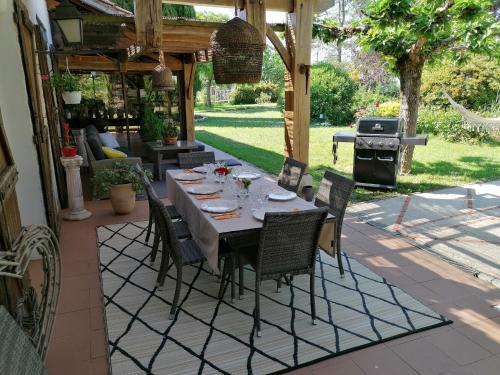 un patio avec une table, des chaises et un barbecue dans l'établissement VILLA LES HAUTS VALLONS, à Puylaroque