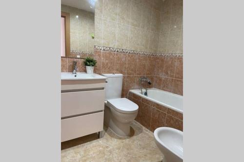 a bathroom with a toilet and a sink and a tub at UIM Mediterraneo Poeta 5 Wifi in Puerto de Sagunto