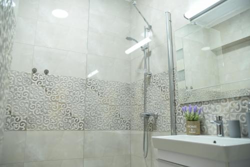 a white bathroom with a shower and a sink at Ideal MoonLight Residence in Mamaia