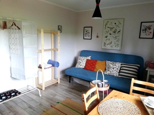 a living room with a blue couch and a table at Pokoje goscinne u Olguni in Chyrowa