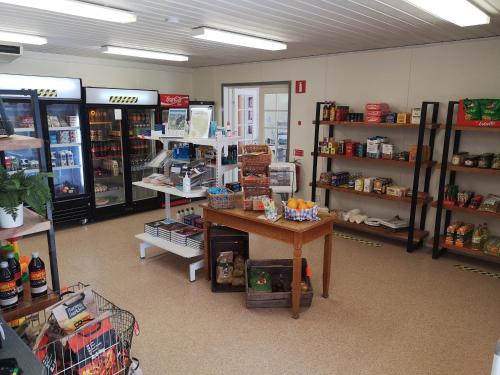 a store aisle with a table and shelves of products at Trysunda Vandrarhem & Skärgårdscafé 