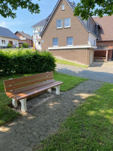 a park bench sitting in the grass in front of a building at familienfreundliche Ferienwohnung Anna in Rollshausen