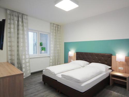 a bedroom with a large bed and a window at Hotel Goldener Adler in Linz